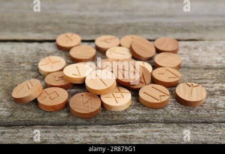 Pile of runes with different symbols on wooden table Stock Photo