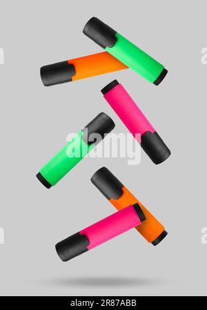 Green, orange and pink markers falling on light background Stock Photo