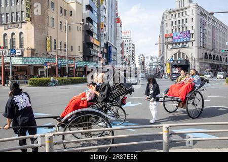 Rickshaw ride in Tokyo, tourists enjoy a ride in traditional rickshaws on Tokyo street,Japan,Asia Stock Photo
