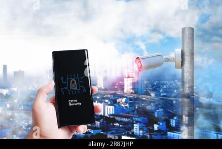 Smartphone screen in hand  displaying a cyber CCTV security concept with a cityscape in the background, Futuristic technology concept, Double exposure Stock Photo