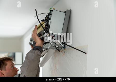 Man technician repairing apartment air conditioner Stock Photo