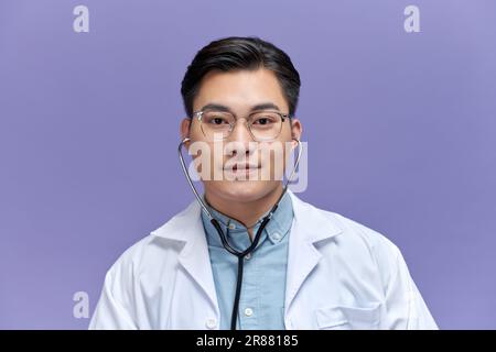 Handsome young man wearing doctor uniform with a happy and cool smile on face Stock Photo
