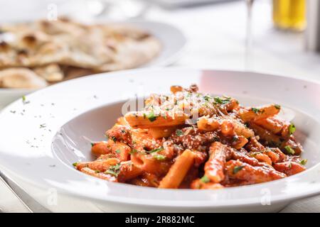 Pomodoro sauce and penne pasta in a aplate with grated hard cheese on top. Stock Photo