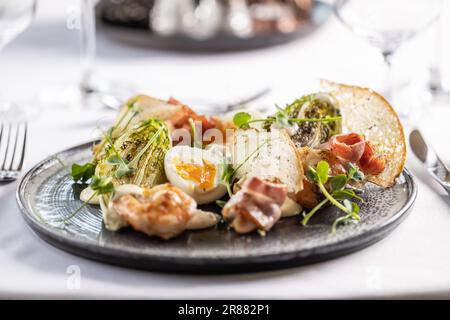 Appetizer in a form of ceasar salad with shrimps, toasts and egg. Stock Photo