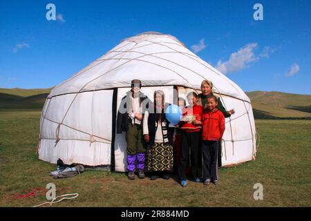 Shepherd family with a tourist in front of their yurt at Songkoel Kyrgyzstan Stock Photo