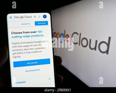 Person holding cellphone with webpage of computing services Google Cloud Platform (GCP) on screen with logo. Focus on center of phone display. Stock Photo