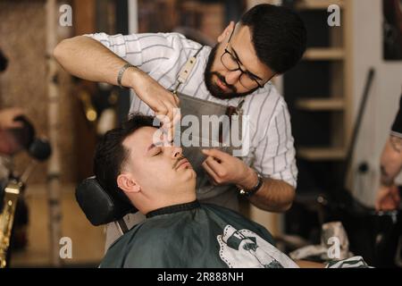 Threading Machine Barber Process of threading procedure in barber shop. Professional barber ...