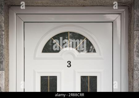 House number three on white wooden door Stock Photo