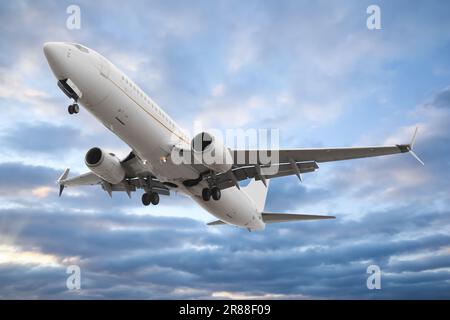Plane in sky during sunset, low angle view Stock Photo