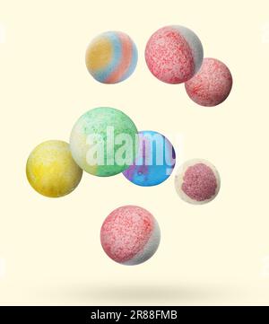 Many different bath bombs falling on beige background Stock Photo