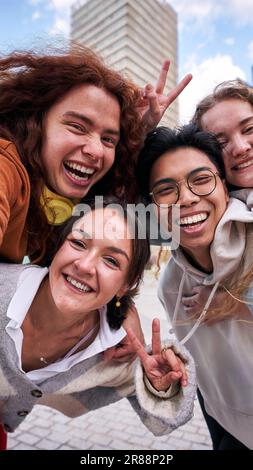 Group of multiracial young people having fun taking a selfie in the city with an smartphone. Stock Photo
