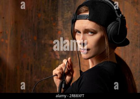 Portrait of serious handsome Caucasian male listens music or audio book,  uses modern wireless headphones, poses against grey background with copy  space for your information advertising or text. Stock Photo | Adobe