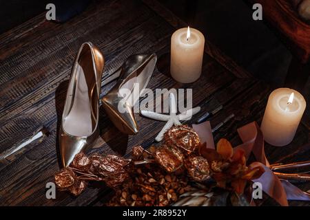 Wedding decor with bride's white shoes, flower bouquet, rings, glasses of champaign on the table. High quality photo Stock Photo