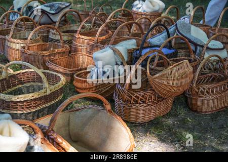 Woven wicker baskets and sheepskin slippers for sale at a historic craft market in Germany, selected focus, narrow depth of field Stock Photo
