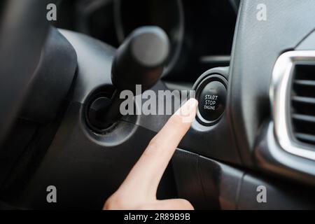 Close up of finger pressing engine start button until engine turns on. Stock Photo