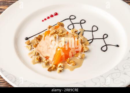 Pumpkin dessert with tahini and walnuts on a white porcelain plate Stock Photo