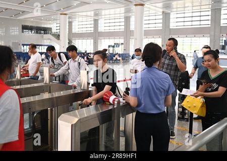 (230620) -- SHENGZHOU, June 20, 2023 (Xinhua) -- Passengers go through ticket gates at Xinchang Railway Station on the Hangzhou-Shaoxing-Taizhou intercity railway in east China's Zhejiang Province, June 19, 2023. The Hangzhou-Shaoxing-Taizhou intercity railway is among China's first group of high-speed railway projects funded by a public-private partnership (PPP), with the private sector having a holding status. Since the railway's official operation in January 2022, more than 10 million passengers have travelled along it. The 266.9-kilometer rail line, with a designed speed of 350 kilometers Stock Photo