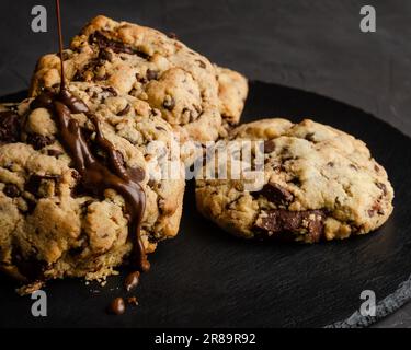 Chocolate chip cookies with chocolate syrup, on black background Stock Photo