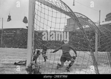 Current 23-3-1947: Dynamo Skeid in winter modeThe 'Dynamo'-'Skeid' match at Bislett was in every respect one of the strangest football matches on the Norwegian field. Before and during the match, it snowed heavily, and the grass was white and hard with snow drifts around when the players made their entrance and were hailed by 32,000 spectators - a record at Bislett. It was a display of good football.  Here comes 'Dynamo's' first goal in the second half, powerful and sharp. It is outer h. Trofimov who is in front. 'Skeid's' second goalkeeper, Arnevaag, did a good job, but did not avoid concedin Stock Photo