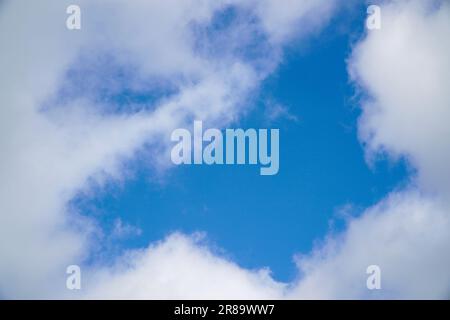 A hole in the white clouds, which is visible the blue sky. Soft focus Stock Photo