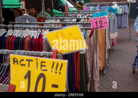 Netherlands, clothes for sale on a market where the vendor has attached notices with  an action prices to his goods. Stock Photo