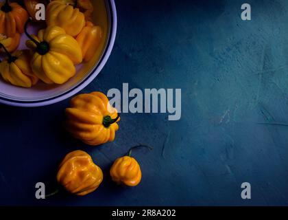 fresh yellow peppers on blue background Stock Photo