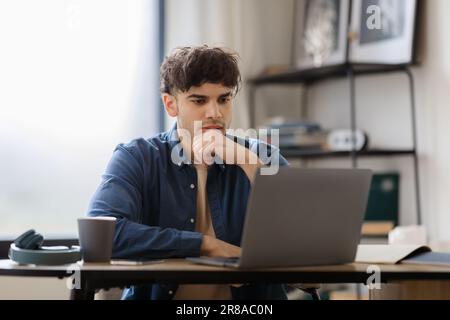 Pensive Arabic Man Looking At Laptop Focused On Work Indoors Stock Photo