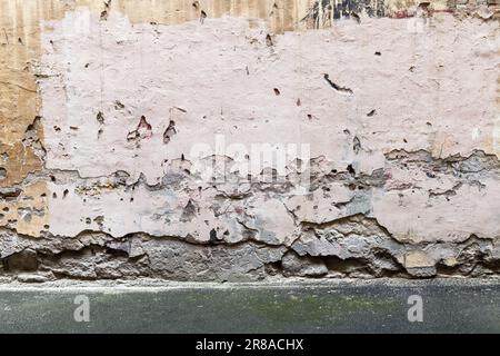 Grunge urban background texture with an old cracked wall and asphalt pavement Stock Photo