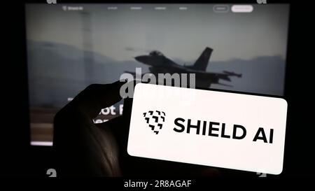 Person holding cellphone with logo of US aerospace and defense company Shield AI on screen in front of business webpage. Focus on phone display. Stock Photo