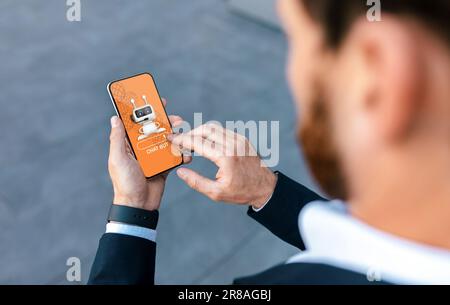 Businessman holding smartphone, using chatbot in business operations Stock Photo