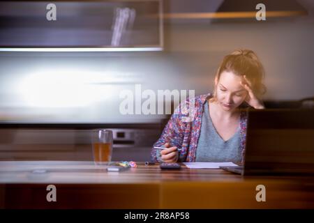Young smiling pretty woman student using laptop elearning or remote working at home office using laptop computer watching webinar, learning web course Stock Photo