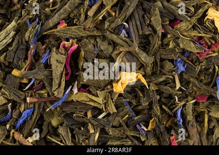 Flavoured green tea with rose petals and exotic fruits - mango, yellow peach and citrus fruits. Stock Photo