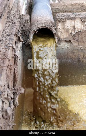 Slurry from cattle shed running into a lagoon where it will be stored after having water separated off it, then spread on the land as a fertiliser. Du Stock Photo