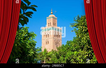 Open theater red curtains against the most important mosque in Marrakech called Kutubiyya or Koutoubia, with the ancient minaret built with bricks acc Stock Photo