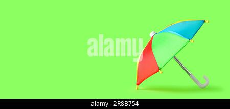 Mini colorful umbrella on green background with space for text Stock Photo