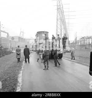 Current 57-3-1960: Giant on city tour Forty wheels rolled in unison from Hasle to Ulven in Oslo the other day. They carried out a historic job: The largest Norwegian-built transformer to date – a giant of 205 tonnes – was transported from Per Kure A/S to the lighting company's facility at Ulven, where it will help with the power supply. The transformer, which produces 161,000 kilovoltampères, is 9.6 meters long and 5.7 meters wide. Oslo Lysverker had called in reinforcements for the large transport and no less than two drivers were in business. They received their driving orders from the comma Stock Photo