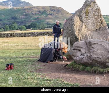 A person performs a dance in front of the stones as the sun begins to set during the Castlerigg Stone Circle Summer Solstice Celebration. It's believed Castlerigg Stone Circle was constructed around 3200 BC, and although its original purpose remains largely unknown, possible uses include a trading post, meeting place, a religious site or an astronomical observatory.Castlerigg Stone Circle, Keswick, United Kingdom, 20th June 2023  (Photo by Mark Cosgrove/News Images) Stock Photo