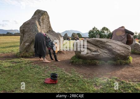 A person performs a dance in front of the stones as the sun begins to set during the Castlerigg Stone Circle Summer Solstice Celebration. It's believed Castlerigg Stone Circle was constructed around 3200 BC, and although its original purpose remains largely unknown, possible uses include a trading post, meeting place, a religious site or an astronomical observatory.Castlerigg Stone Circle, Keswick, United Kingdom, 20th June 2023  (Photo by Mark Cosgrove/News Images) Stock Photo