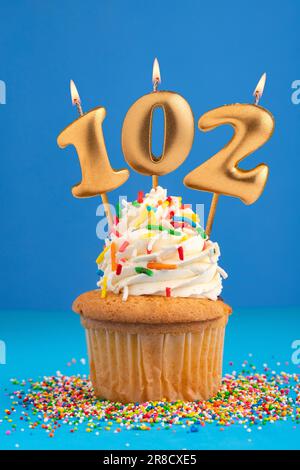 Blue candle number 102 - Birthday on yellow background Stock Photo - Alamy
