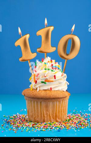 Birthday cake with candle number 110 - Blue background Stock Photo