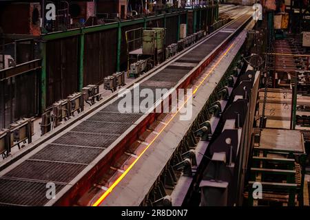Rolled metal factory hot steel bar moving on conveyor. Stock Photo