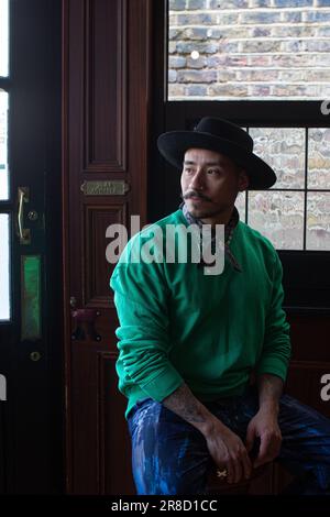 Young man with hat sitting in a Hackney pub , London, UK Stock Photo
