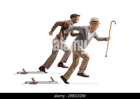 Full length profile shot of two elderly men starting a run from starting blocks isolated on white background Stock Photo