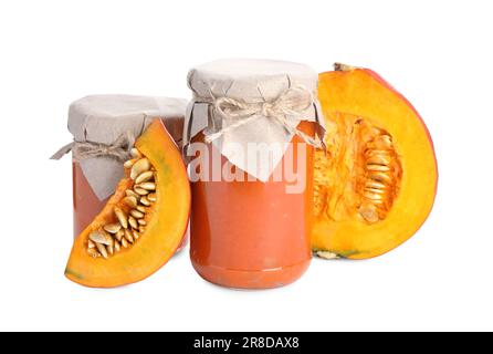 Jars of pumpkin jam and fresh pumpkin on white background Stock Photo
