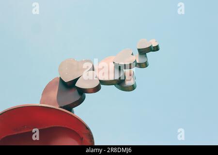 A heart-shaped sculpture with a blue sky in the background Stock Photo