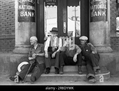Milton, Washington:  1941 Men sitting on the steps of the Valley National Bank. Stock Photo