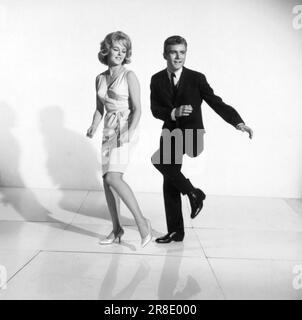 United States:  c. 1961 A photograph of a couple demonstrating how to dance the twist. Stock Photo