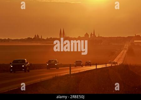 Halberstadt, Germany. 21st June, 2023. The light of the morning sun settles on the foothills of the Harz Mountains near Halberstadt at the summer solstice. In the background, the towers of the cathedral and the Martini church can be seen. At the astronomical beginning of summer there can be up to 17 hours of sunshine. It is the longest day of the year. Credit: Matthias Bein/dpa/Alamy Live News Stock Photo