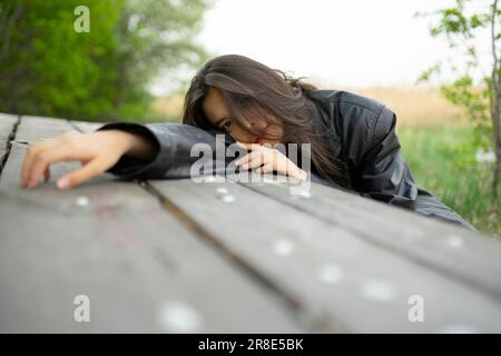 Portrait of teenage girl (16-17) leaning on picnic table Stock Photo