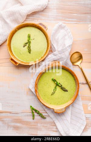 Creamy asparagus soup on wooden background Stock Photo